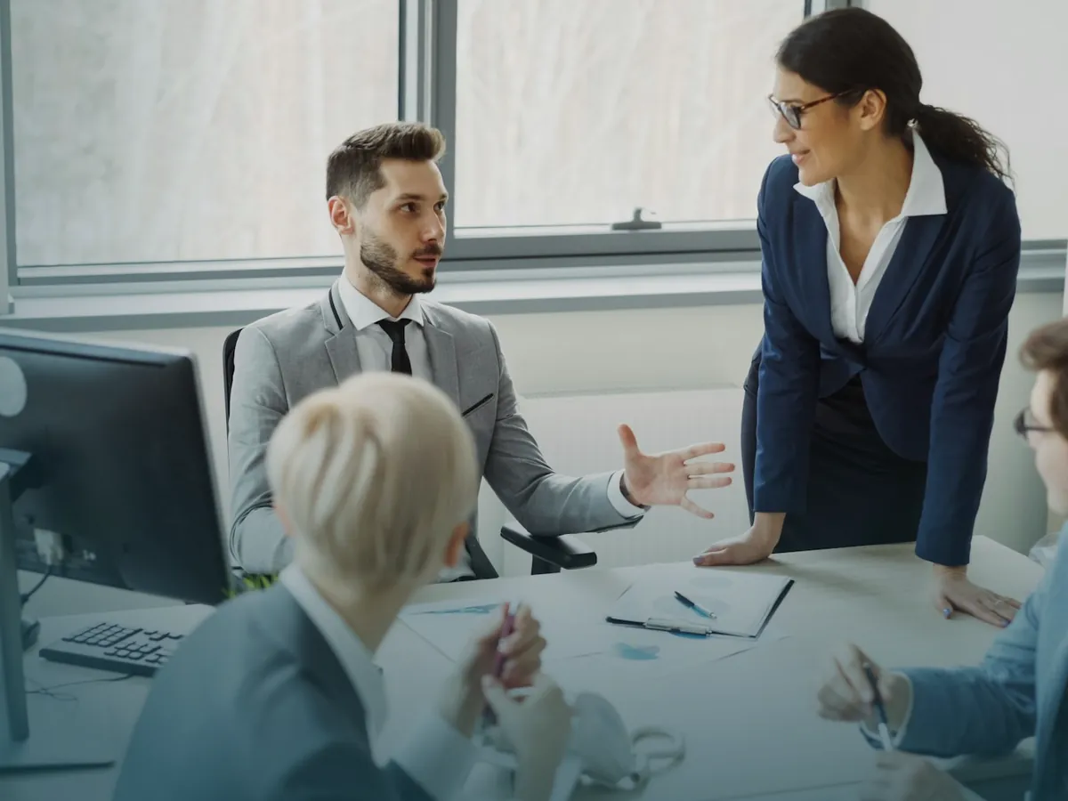 Consultora de Qantta trabajando en equipo con el personal de una empresa cliente alrededor de una mesa